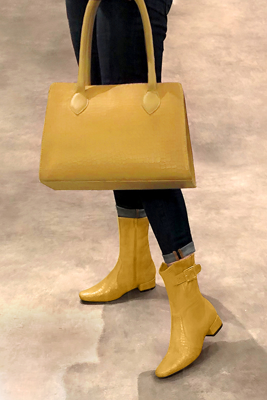 Mustard yellow women's ankle boots with buckles on the sides. Round toe. Low block heels. Worn view - Florence KOOIJMAN